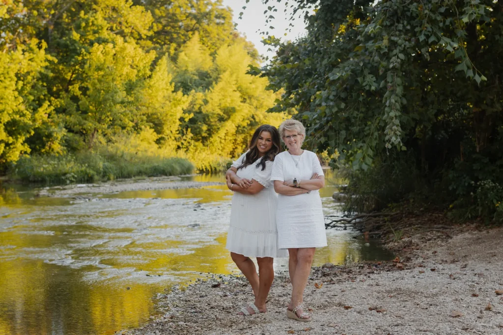 two women in front of a river